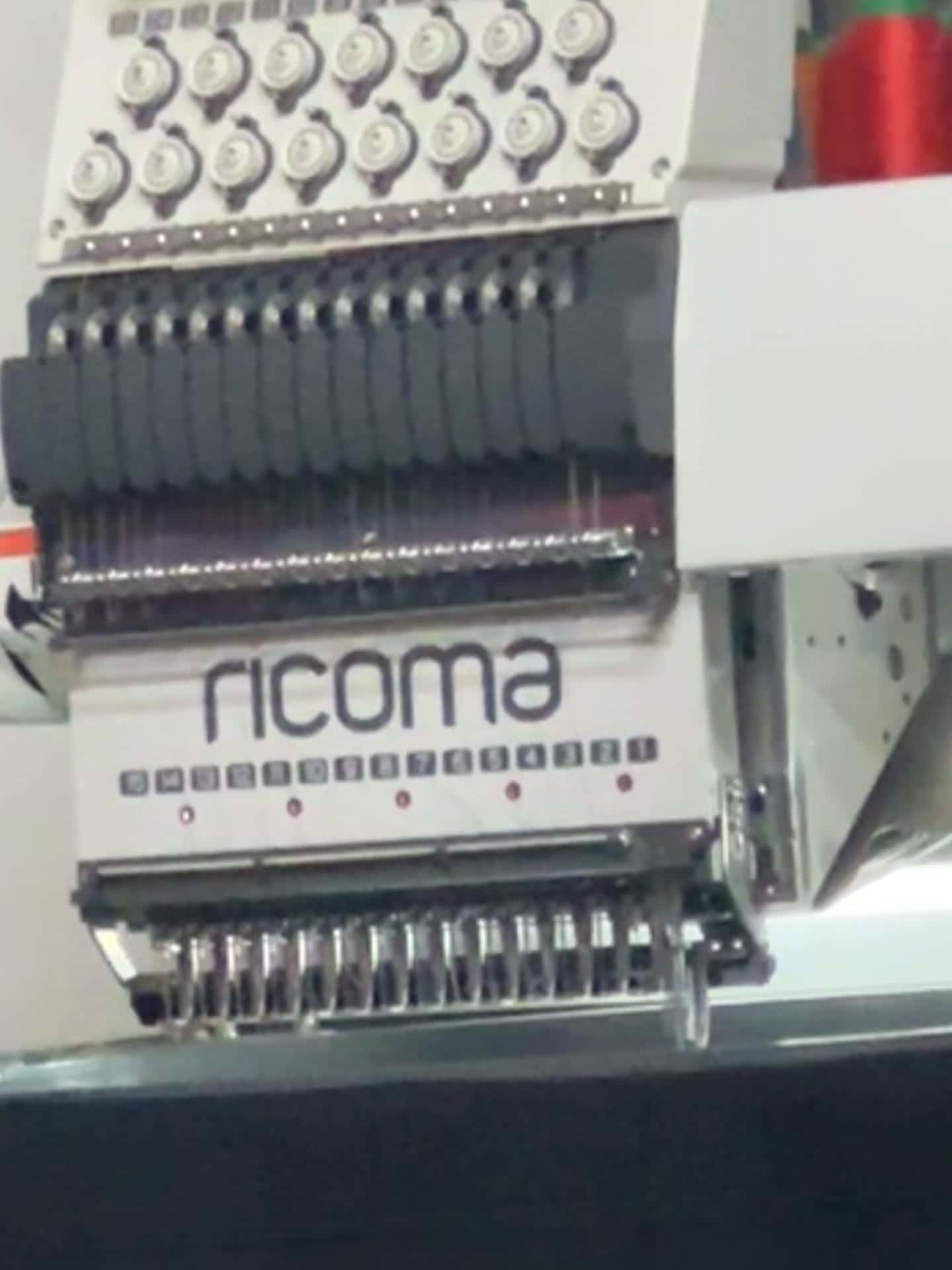 The needle head of the Ricoma embroidery machine in the South West Apparel workshop, numbered 1 to 15, above a hooped black garment