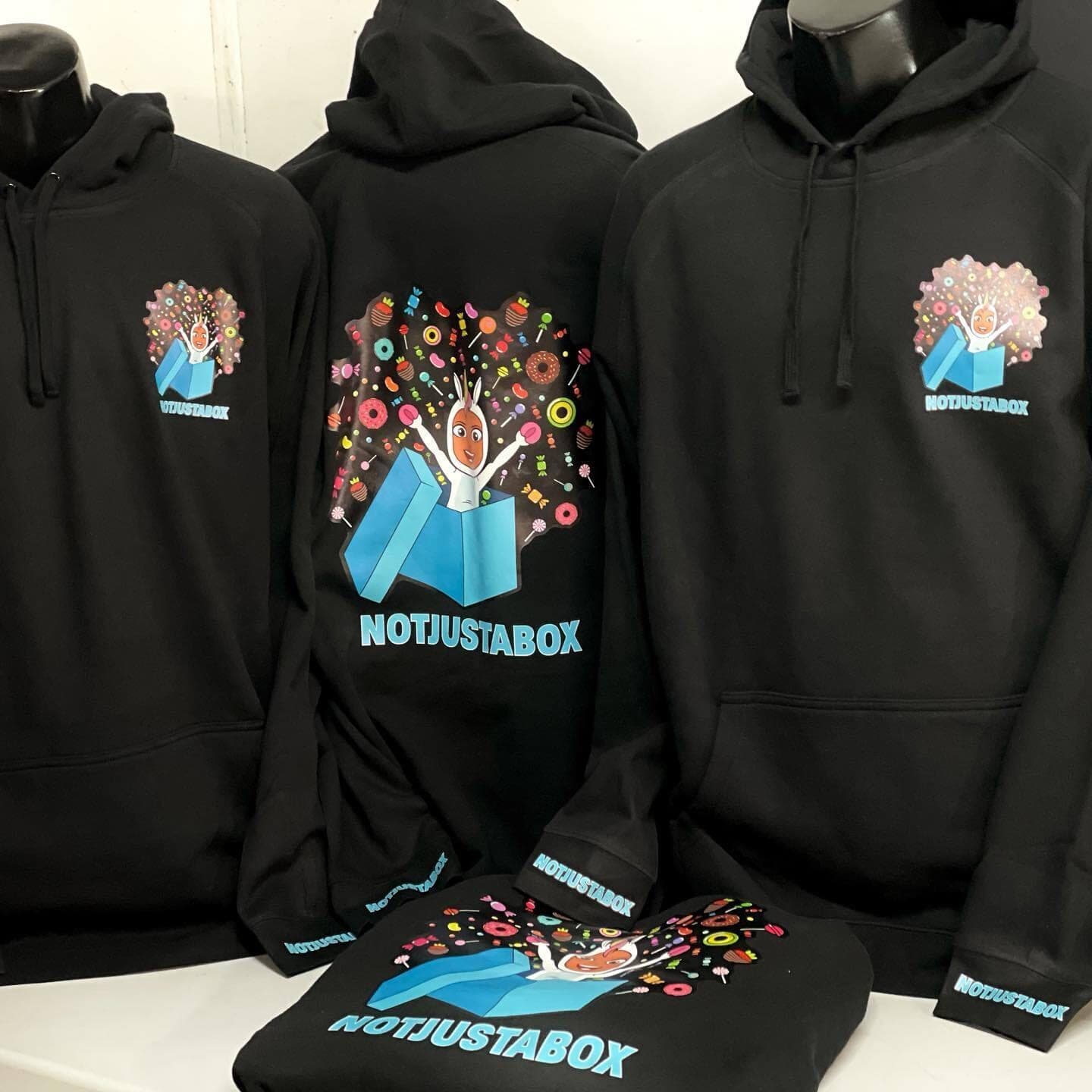 Black Not Just a Box hoodies with a full-colour illustrated logo on the front and back